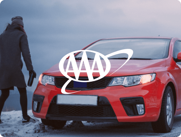 man standing next to red card on snowy road with AAA logo overlay