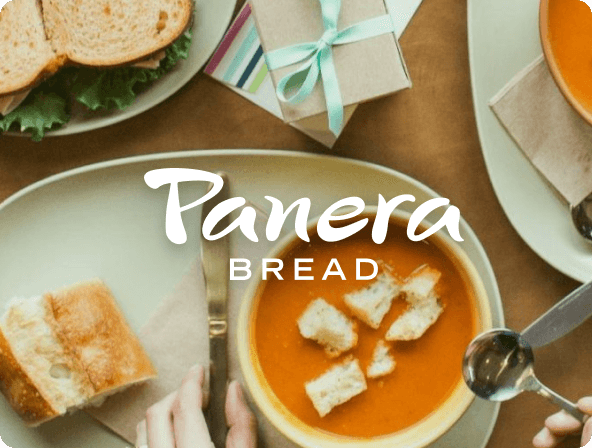 Top down picture of bowl of soup with small sandwich next to it.  Panera Bread logo overlay